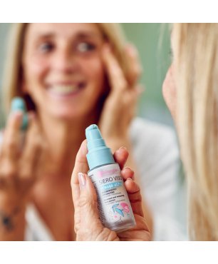 Signora allo specchio applica il siero alle ceramidi e fitoretinolo