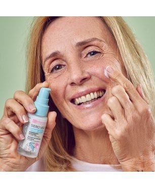 Signora sorridente applica il siero viso antiage