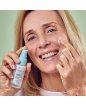 Signora sorridente applica il siero viso antiage
